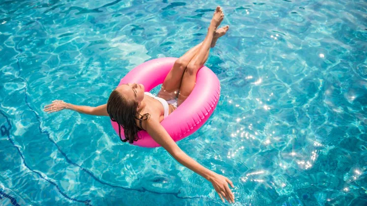 Una mujer se baña en la piscina con un flotador