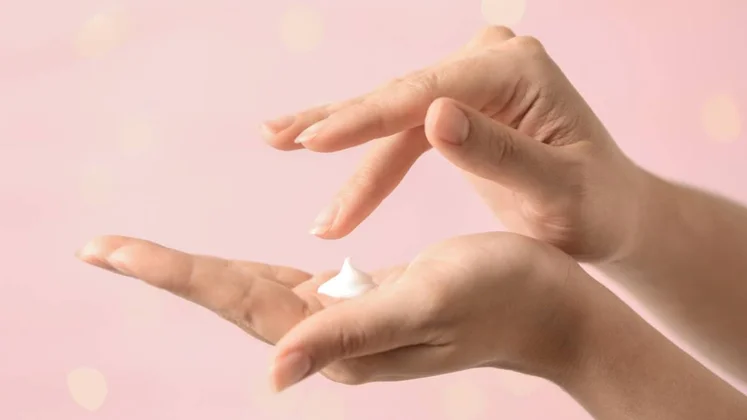 Manos de mujer con crema.