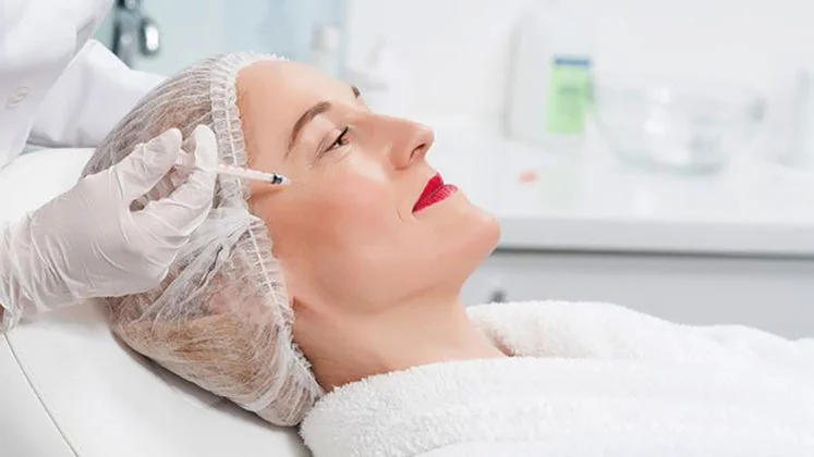 Mujer madura a la que aplican una inyección en el cutis.